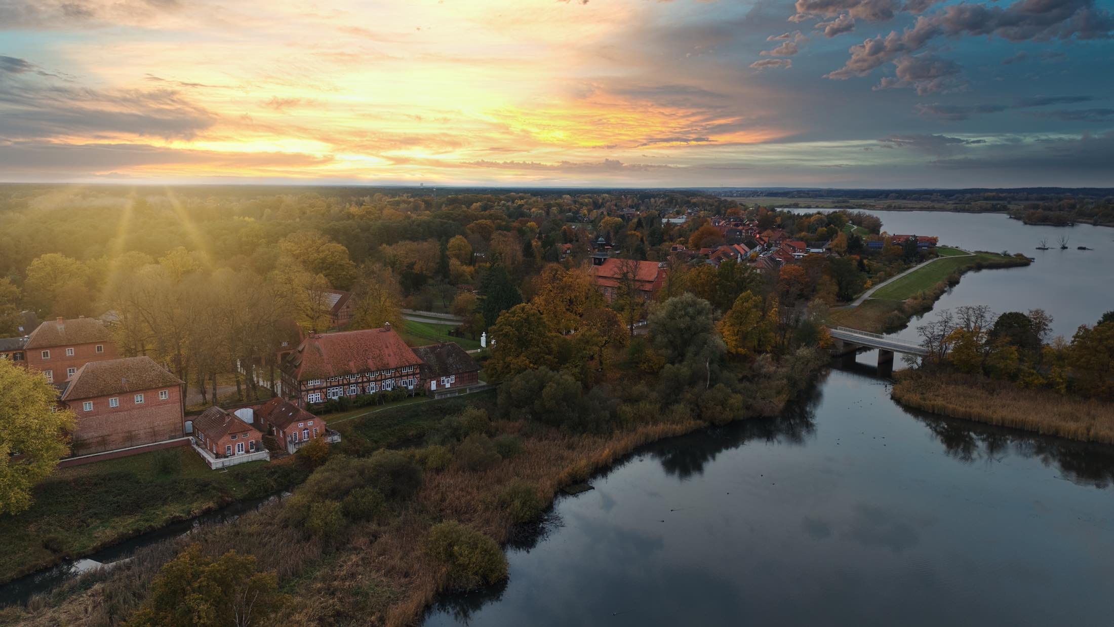 Testseite Full A mother with her child in a carrier backpack hiking through a forest trail on a crisp autumn day.